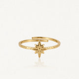 Bague ajustable en acier inoxydable doré. L'anneau martelé est orné d'une étoile rose des vents finement gravée.