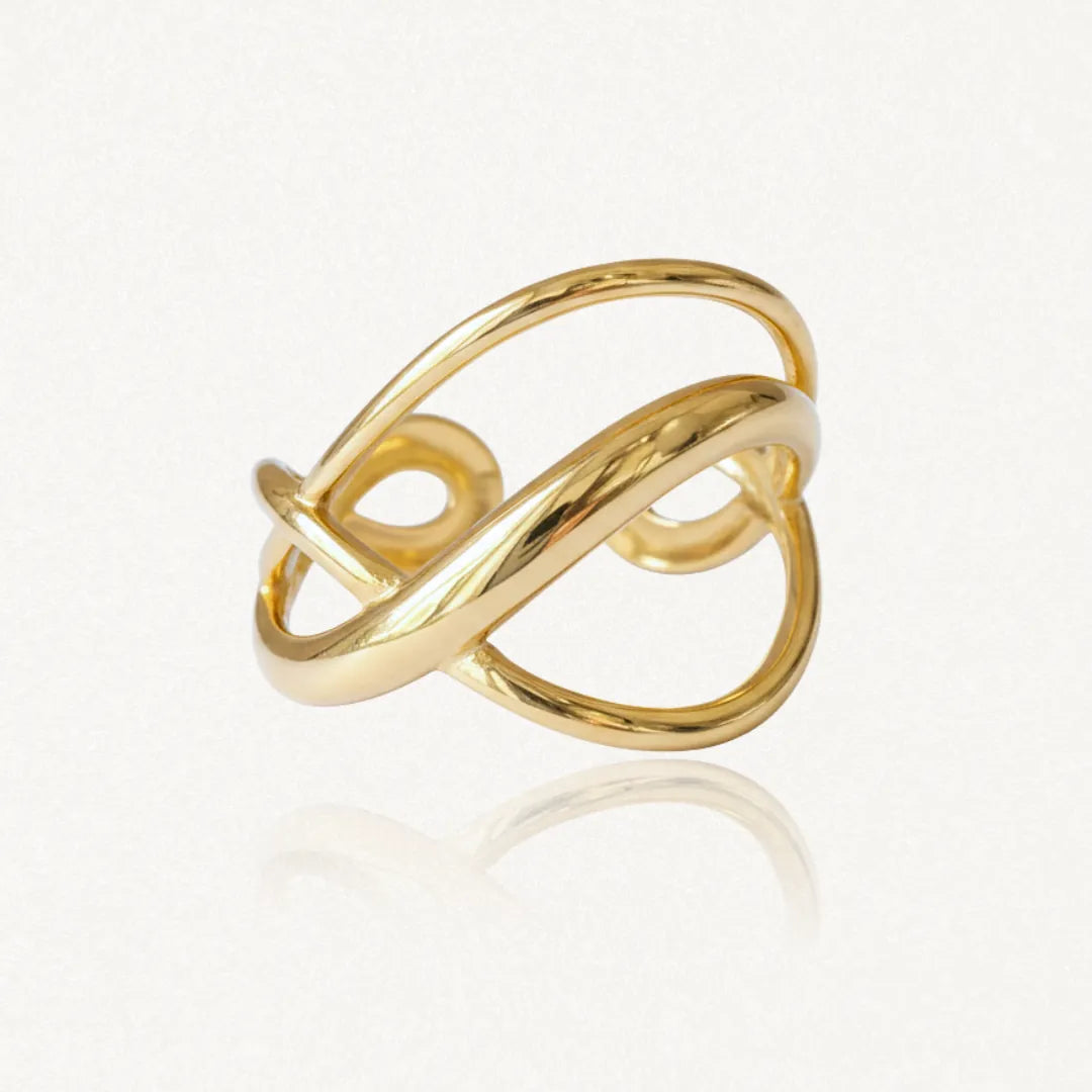 Bague en acier inoxydable doré, design ondulé avec des bandes entrelacées. Sa texture est lisse et très brillante. Hauteur
