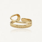 Bague ajustable en acier inoxydable doré, avec une bande formant une boucle, une lisse et une perlée.