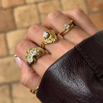 Bague Amalia en acier inoxydable doré avec une surface texturée et un strass en zirconium sur le doigt du milieu