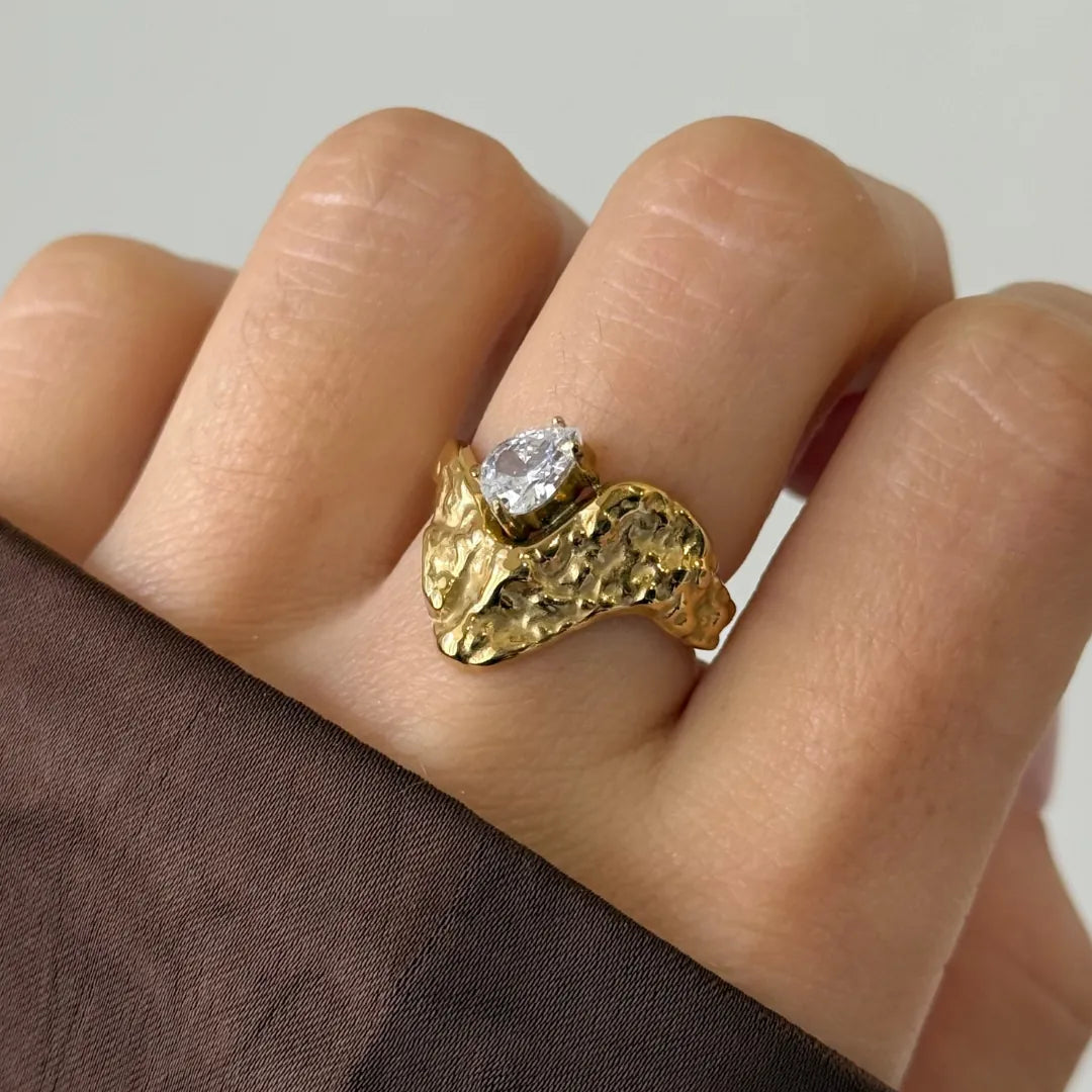 Bague Amalia en acier inoxydable doré avec une texture irrégulière et un strass en zirconium en forme de poire