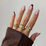 Bague Amalia en acier inoxydable doré avec strass en zirconium sur une main aux ongles manucurés