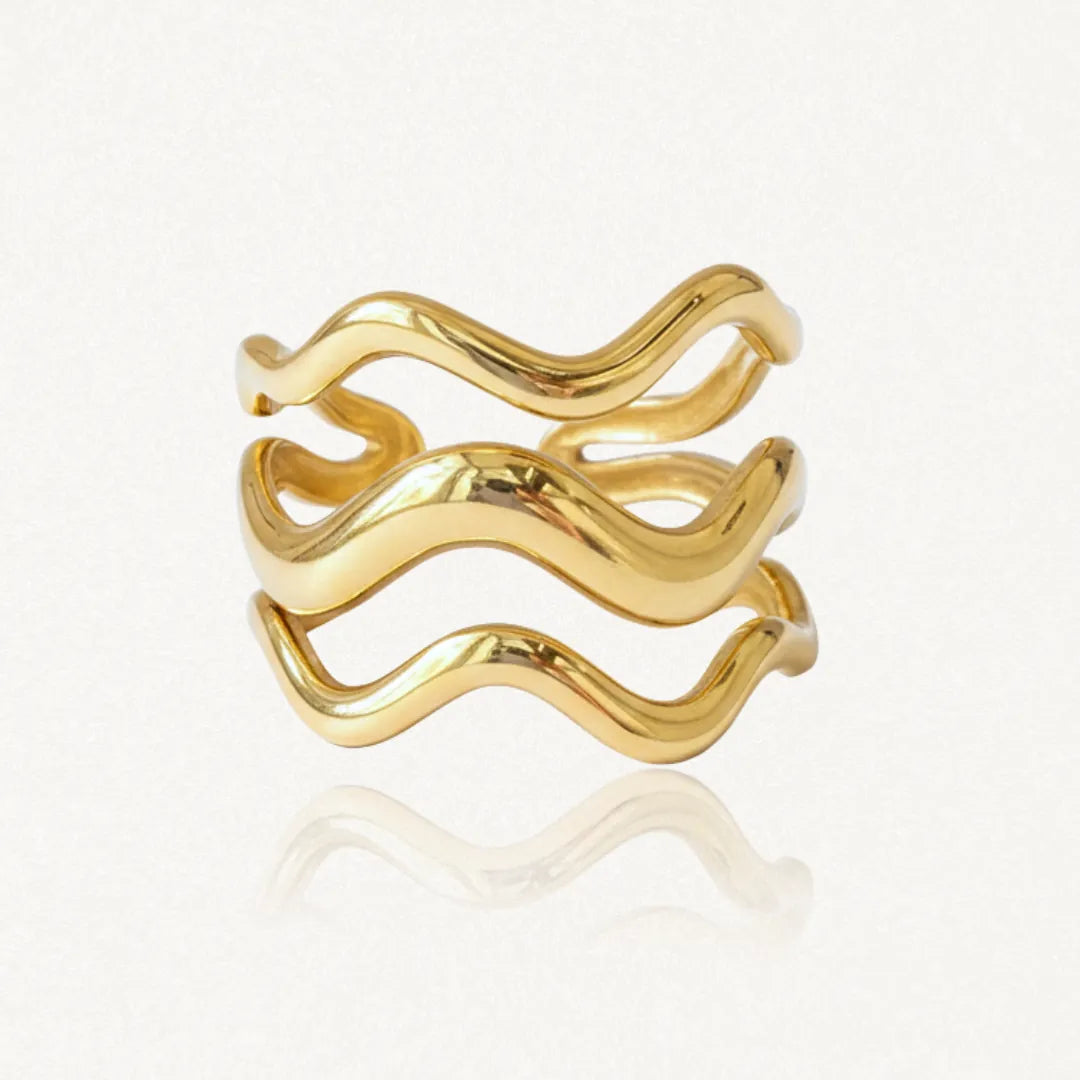 Bague en acier inoxydable doré, composée de trois bandes ondulées lisses et brillantes.