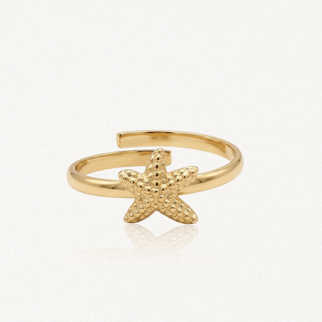 Bague ajustable en acier inoxydable doré, ornée d'une étoile de mer texturée et granulée.