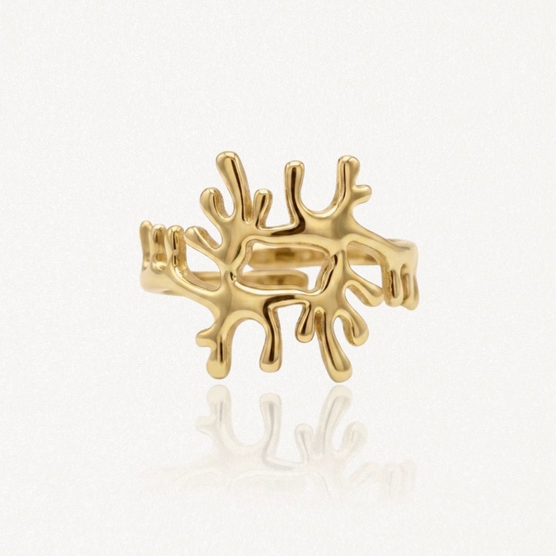 Bague en acier inoxydable dorée, motif abstrait organique aux formes irrégulières et ramifiées, design contemporain.