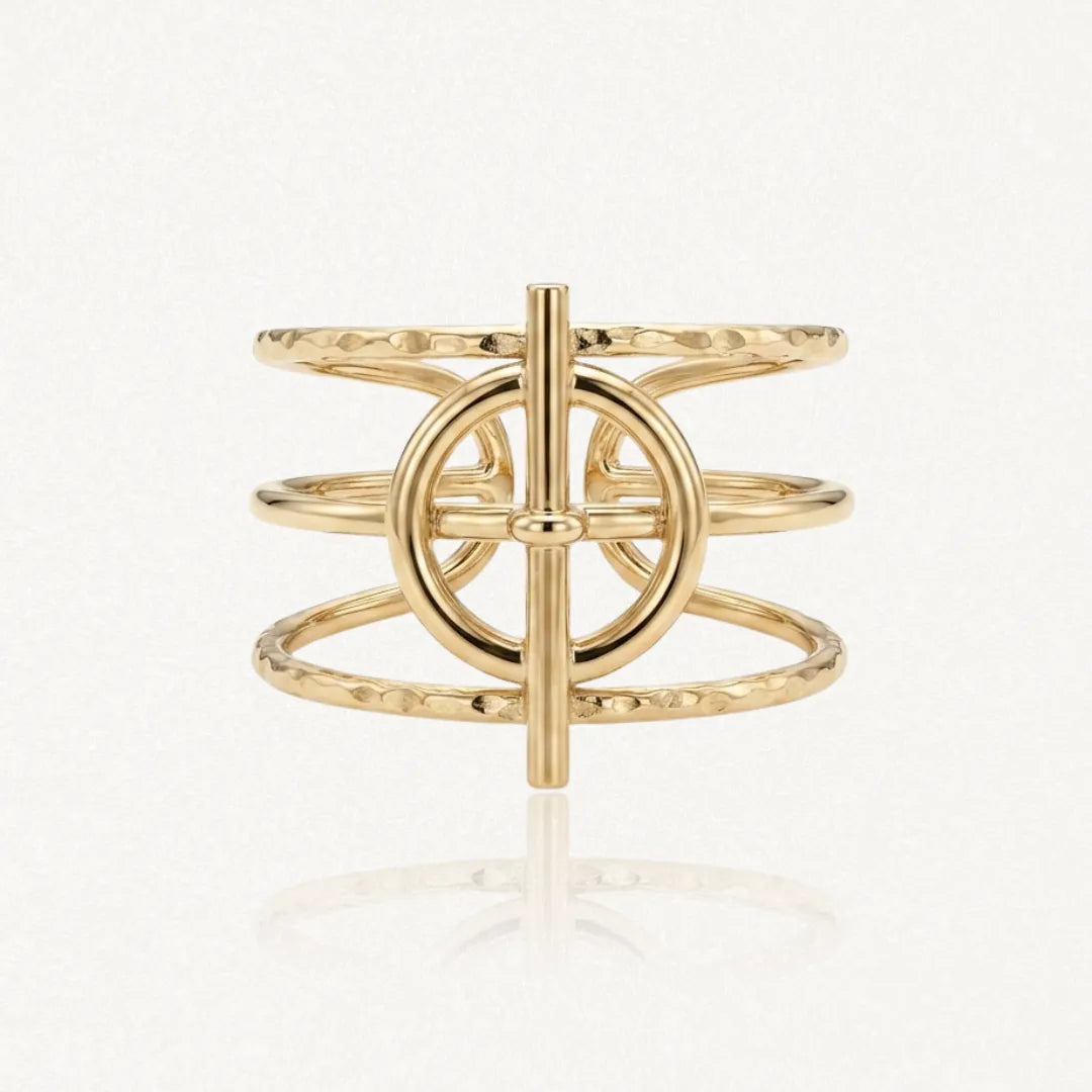 Bague en acier inoxydable doré. Ses trois rangs martelés encadrent un motif central cercle barre.