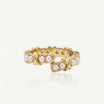 Bague en acier inoxydable doré, ornée de perles synthétiques et de motifs X. Design ouvert.