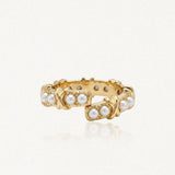Bague en acier inoxydable doré, ornée de perles synthétiques et de motifs X. Design ouvert.