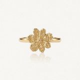 Bague en acier inoxydable doré. Motif de fleur texturée et granuleuse à six pétales, centre détaillé.