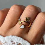 Bague en acier inoxydable dorée, avec motifs floraux, un petit strass et une pierre naturelle de jade blanc en goutte, portée