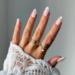 Bague ajustable en acier inoxydable doré, motif fleur et branche, avec une pierre naturelle de jade blanc en forme de pétale.