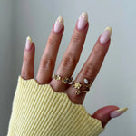 Plusieurs bagues en acier inoxydable doré à motifs floraux et feuilles, dont une bague enveloppante avec pierre ovale, sur