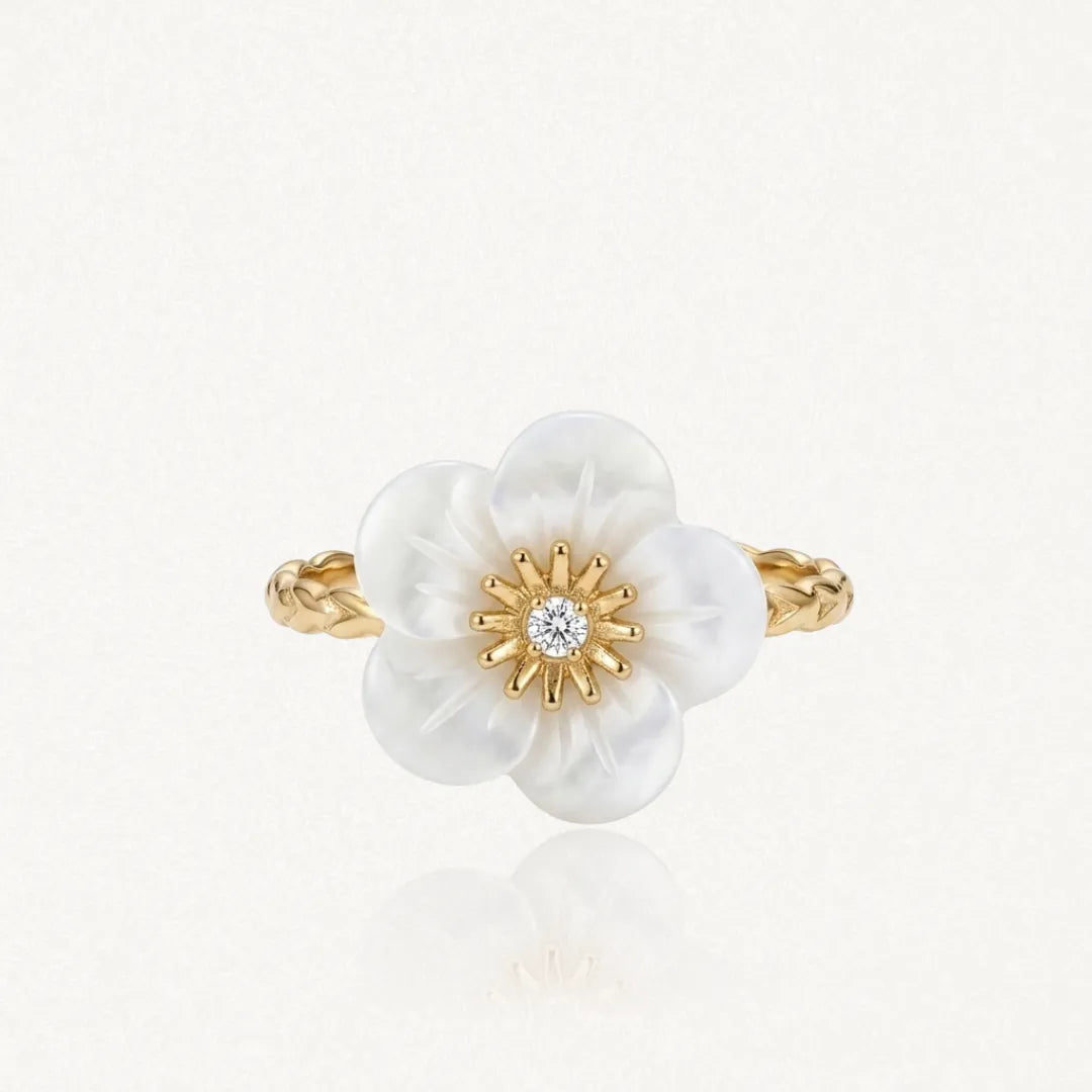 Bague fleur en nacre, centre zirconium. Anneau texturé en acier inoxydable doré.