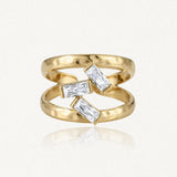 Bague double anneau en acier inoxydable doré martelé, ornée de trois pierres baguette en Zirconium entre les deux bandes.