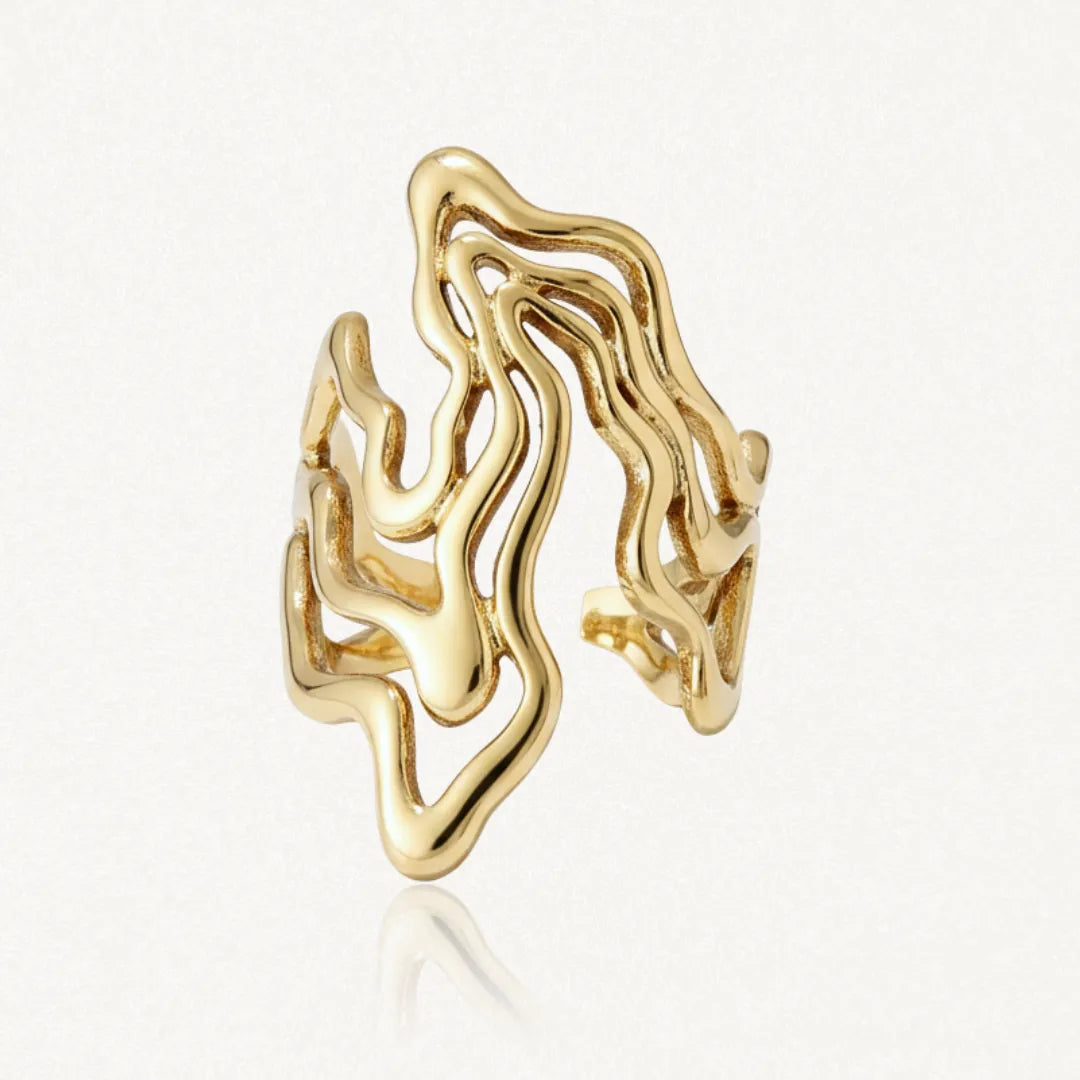 Bague ouverte en acier inoxydable doré, au design organique avec des formes ondulées et une texture lisse.