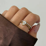 Bague Elizabeth en acier inoxydable doré avec un strass en zirconium en forme de poire et un anneau fin pavé