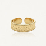 Bague ajustable en acier inoxydable doré, avec un motif martelé et des bordures perlées.