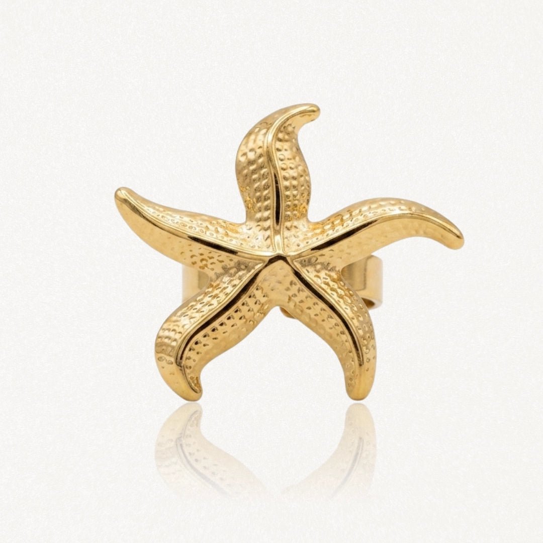 Bague en acier inoxydable dorée, motif étoile de mer texturé et brillant.
