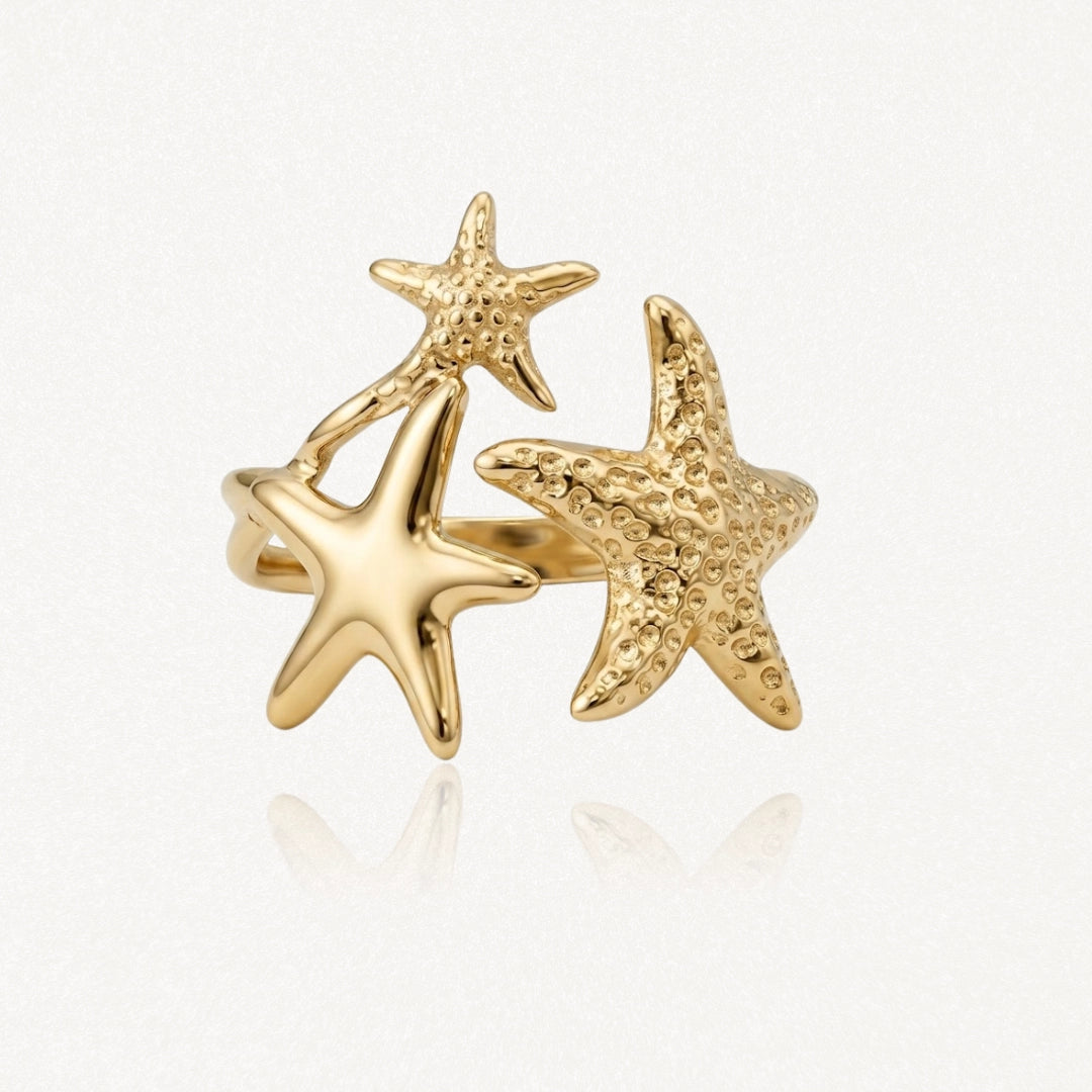 Bague en acier inoxydable doré, ornée de trois étoiles de mer: deux texturées et une lisse. Bijou d'inspiration marine.