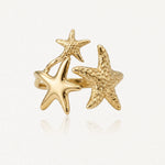 Bague en acier inoxydable doré, ornée de trois étoiles de mer: deux texturées et une lisse. Bijou d'inspiration marine.