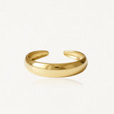 Bague ouverte en acier inoxydable doré à la texture lisse ondulée haute brillance.