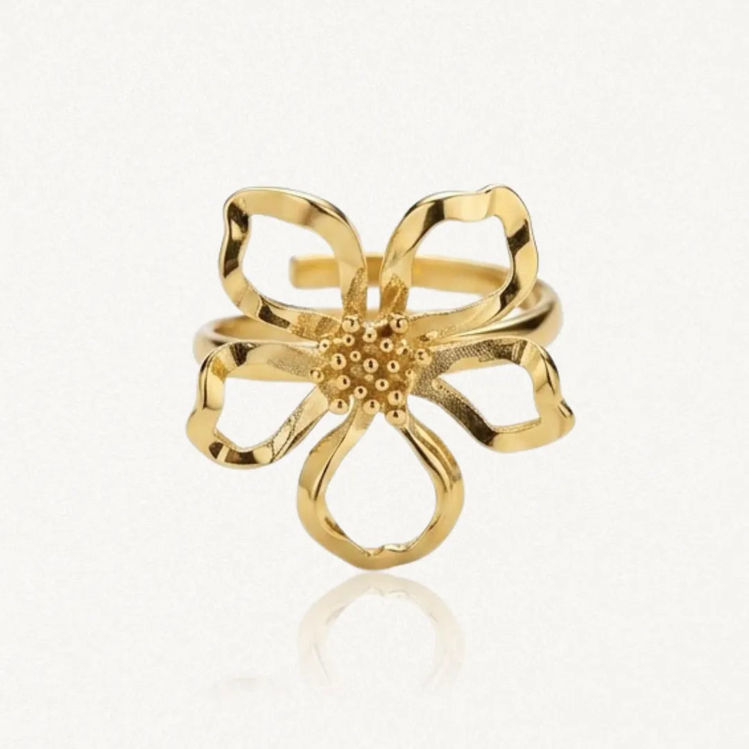 Bague fleur en acier inoxydable doré, avec cinq pétales ajourés et un cœur texturé de petits points.