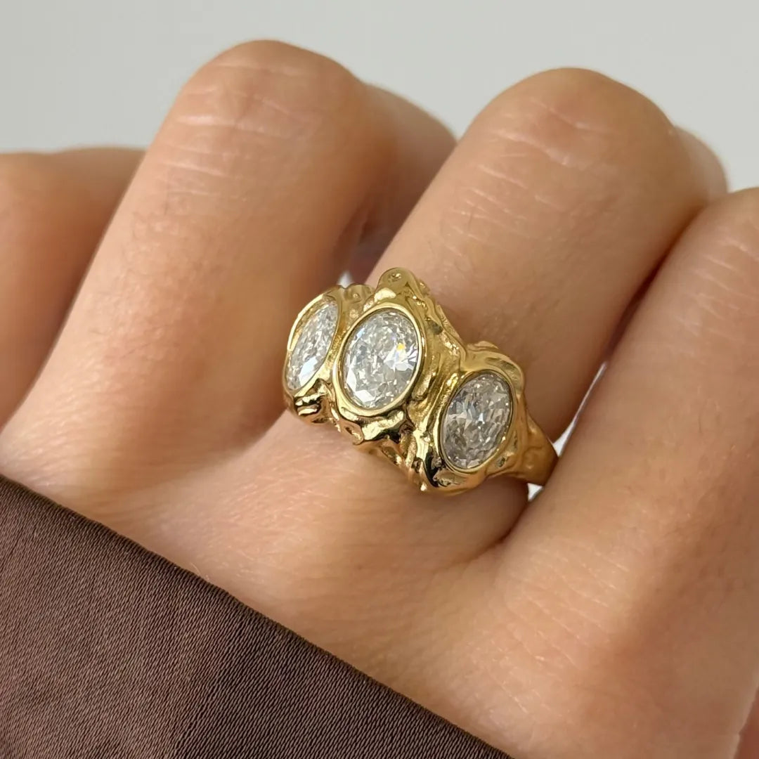 Bague GIGI en acier inoxydable doré avec trois strass en zirconium ovales sertis sur une structure texturée