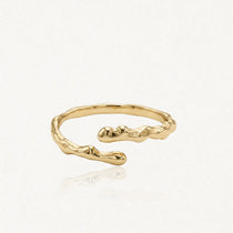 Bague ajustable en acier inoxydable doré, de forme organique irrégulière et texturée.