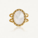 Bague dorée à double corps, ornée d'une pierre ovale blanche facettée dans un serti torsadé.