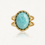 Bague en métal doré, ornée d'une pierre ovale turquoise marbrée de blanc. La monture et l'anneau double sont torsadés.