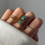 Bague en acier inoxydable doré, avec une pierre naturelle rectangulaire en Jade Blanc et Amazonite au bord perlé.