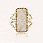 Bague dorée avec une pierre rectangulaire crème veinée, sertie dans un cadre à petits points et un double anneau.