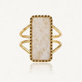 Bague dorée avec une pierre rectangulaire crème veinée, sertie dans un cadre à petits points et un double anneau.