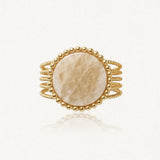 Bague dorée avec cabochon rond marbré beige, bordé de billes dorées et flancs en fils torsadés.