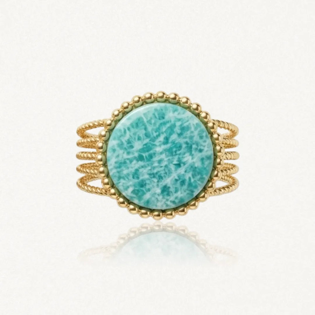 Bague large dorée à plusieurs anneaux tressés, avec une pierre centrale ronde bleu-vert veinée et un pourtour de petites