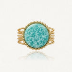 Bague large dorée à plusieurs anneaux tressés, avec une pierre centrale ronde bleu-vert veinée et un pourtour de petites