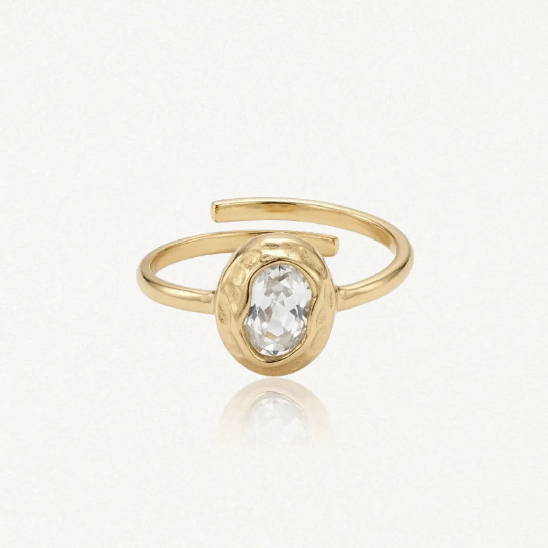 Bague Kendall en acier inoxydable doré avec une pierre centrale ovale transparente sertie dans un contour martelé