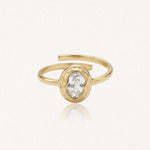 Bague Kendall en acier inoxydable doré avec une pierre centrale ovale transparente sertie dans un contour martelé