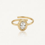 Bague Kendall en acier inoxydable doré avec une pierre centrale ovale transparente sertie dans un contour martelé