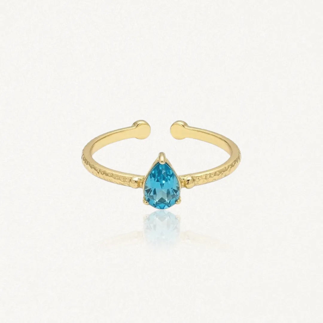 Bague Leandra ouverte en acier inoxydable doré avec une pierre bleue en forme de goutte et une texture martelée