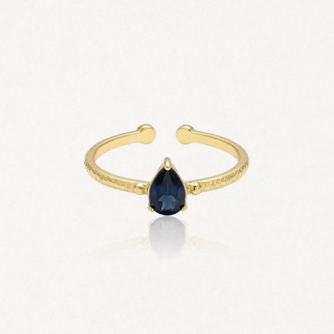 Bague Leandra ouverte en acier inoxydable doré avec une pierre bleue en forme de goutte au centre