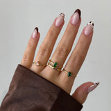 Bague Leandra en acier inoxydable doré avec un strass en zirconium vert en forme de poire sur un anneau fin