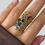 Bague Leandra en acier inoxydable doré avec un strass en zirconium en forme de goutte porté sur un doigt