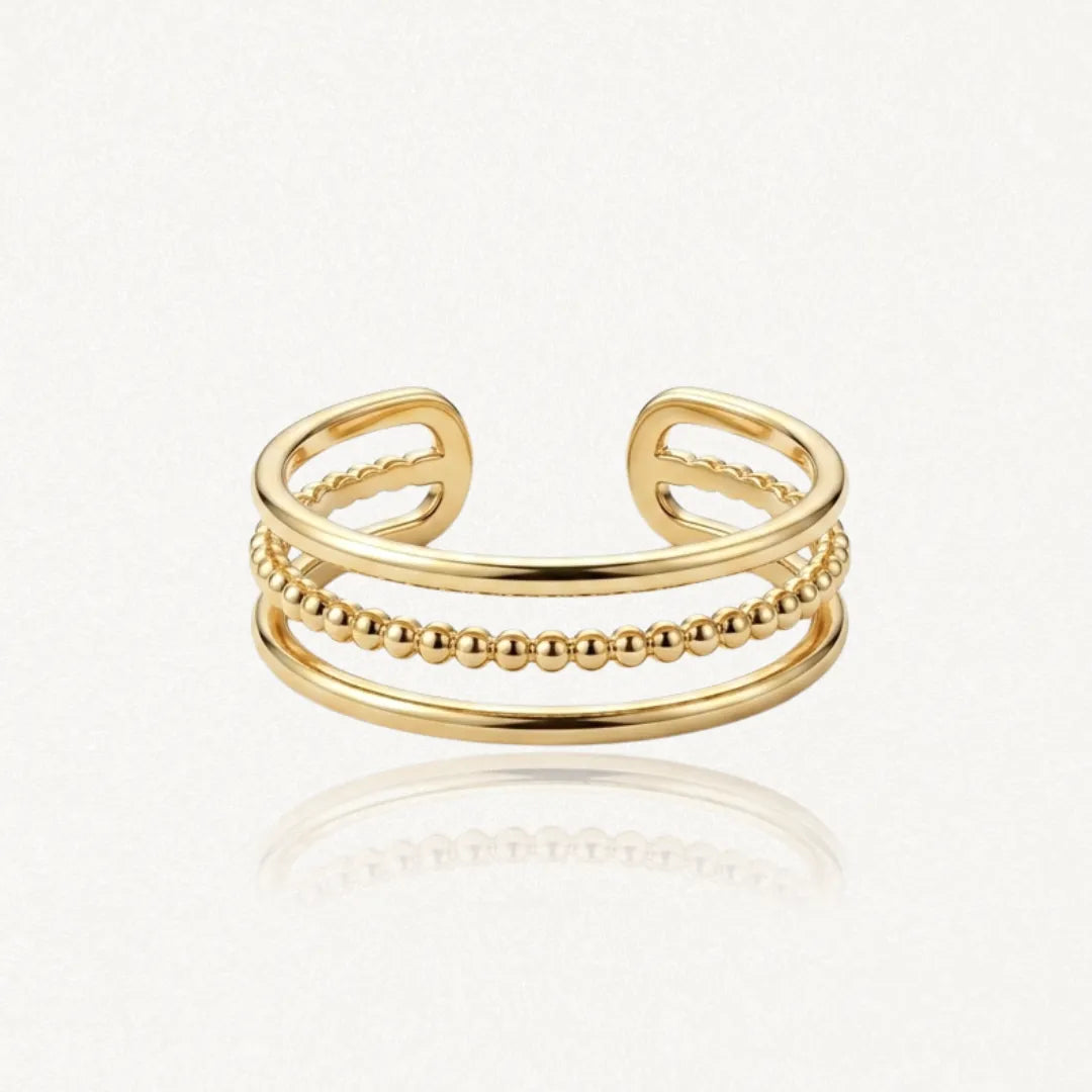Bague ajustable en acier inoxydable doré, composée de trois anneaux : un rang central de billes et deux rangs lisses.