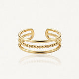 Bague ajustable en acier inoxydable doré, composée de trois anneaux : un rang central de billes et deux rangs lisses.
