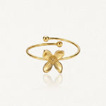 Bague fleur en acier inoxydable doré, avec quatre pétales lisses et un centre pointillé, à anneau ouvert.