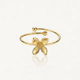 Bague fleur en acier inoxydable doré, avec quatre pétales lisses et un centre pointillé, à anneau ouvert.