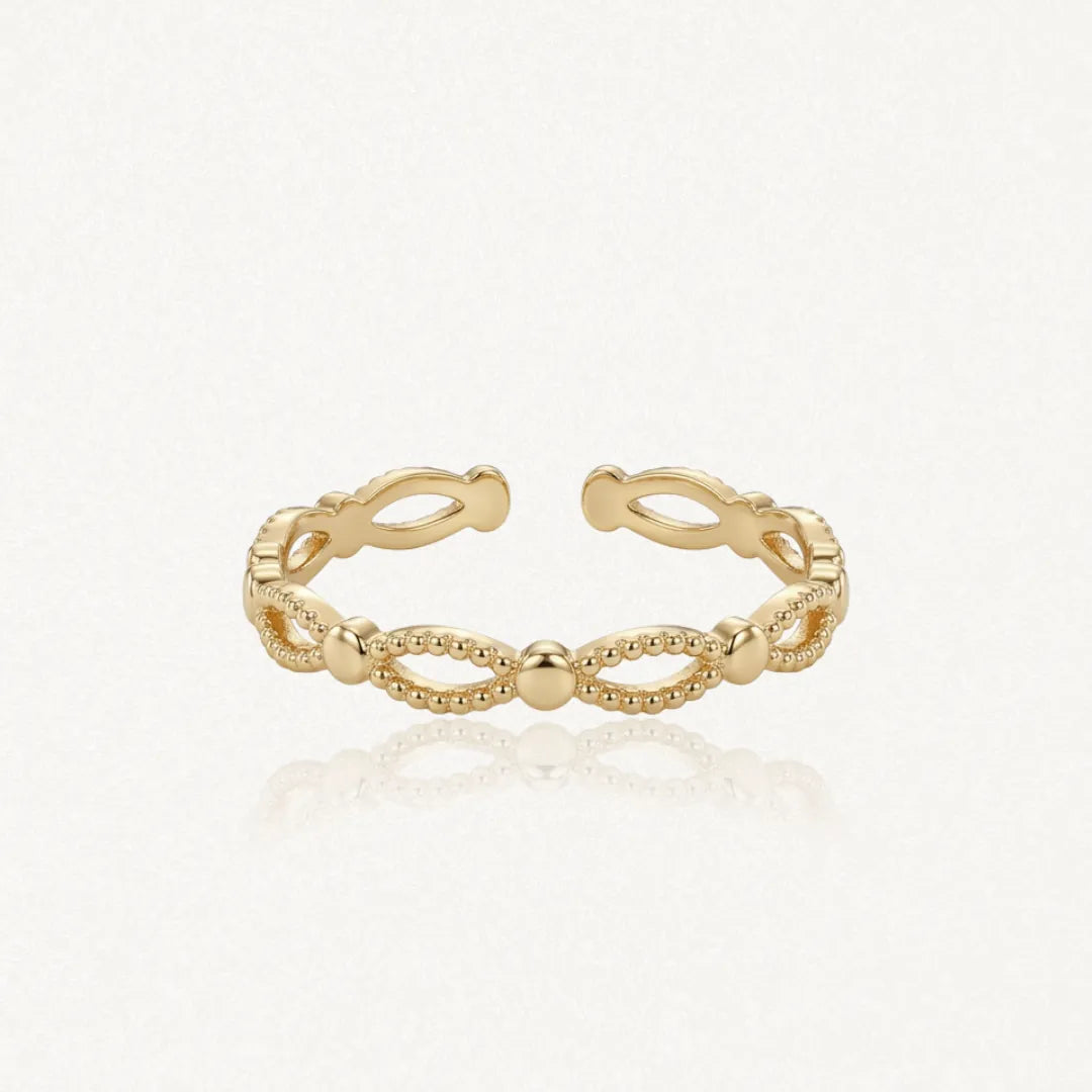 Bague ajustable en acier inoxydable doré, motif de billes et d'ovales ajourés.