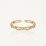Bague ajustable en acier inoxydable doré, motif de billes et d'ovales ajourés.
