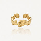 Bague ouverte ajustable en acier inoxydable doré, motif coquillages stylisés avec nervures, finition brillante.
